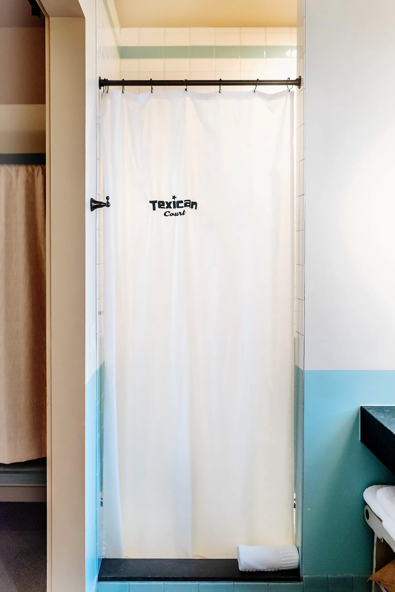Walk in shower with Texican Court shower curtain in a guestroom at the Texican Court Hotel