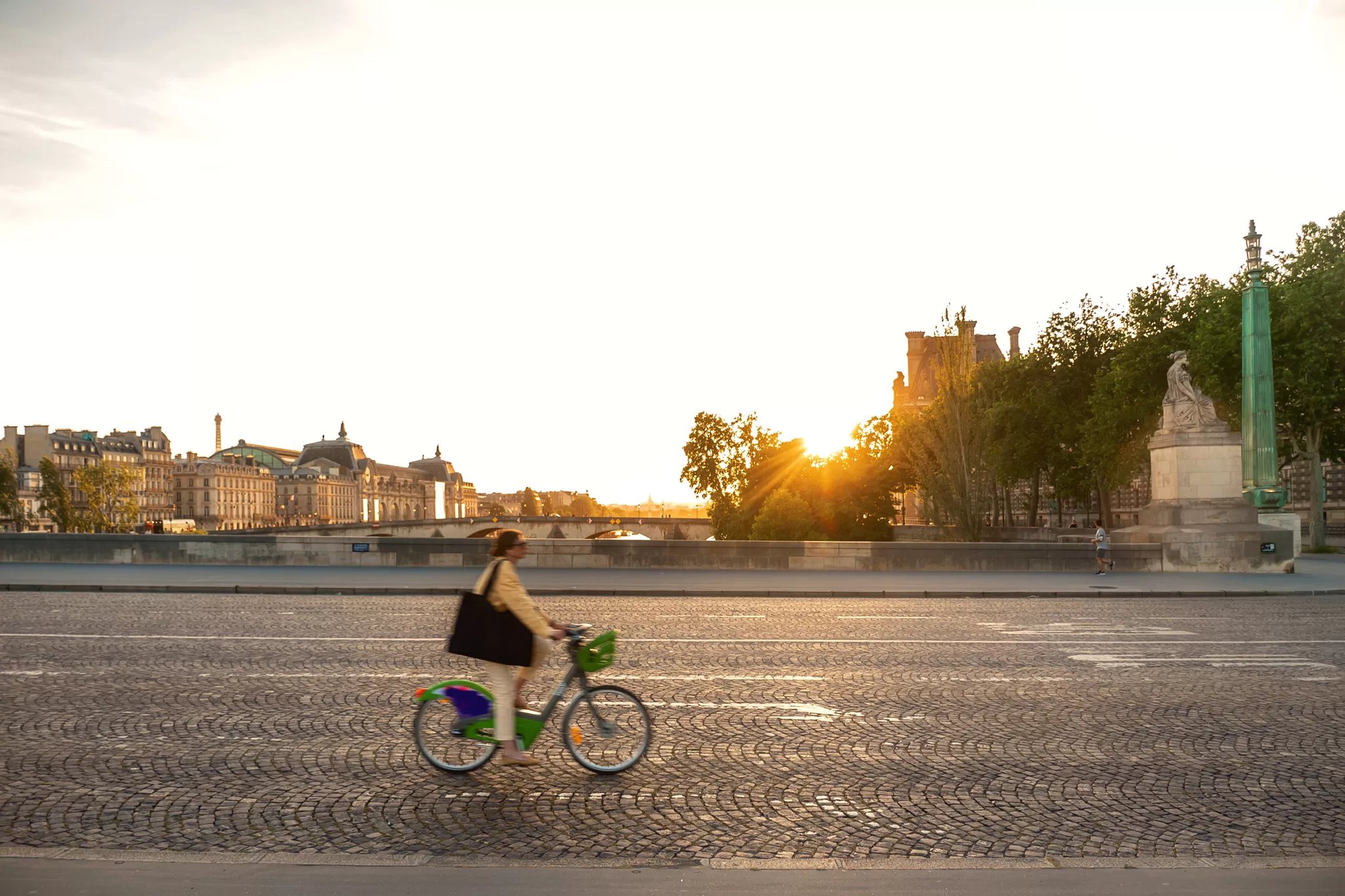 Girl riding her bike across  bridge in Paris 