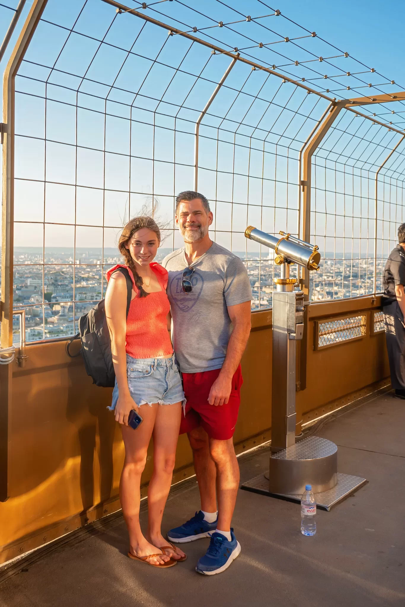 A Girls and her Dad standing on the 2nd floor of the Eiffel Tower at sunset