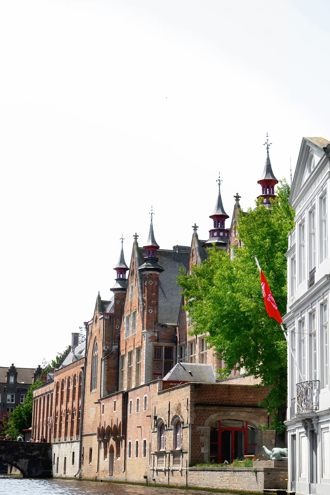 This Bruges itinerary blog post image shows a series of buildings along the water. Taken from a canal tour boat.