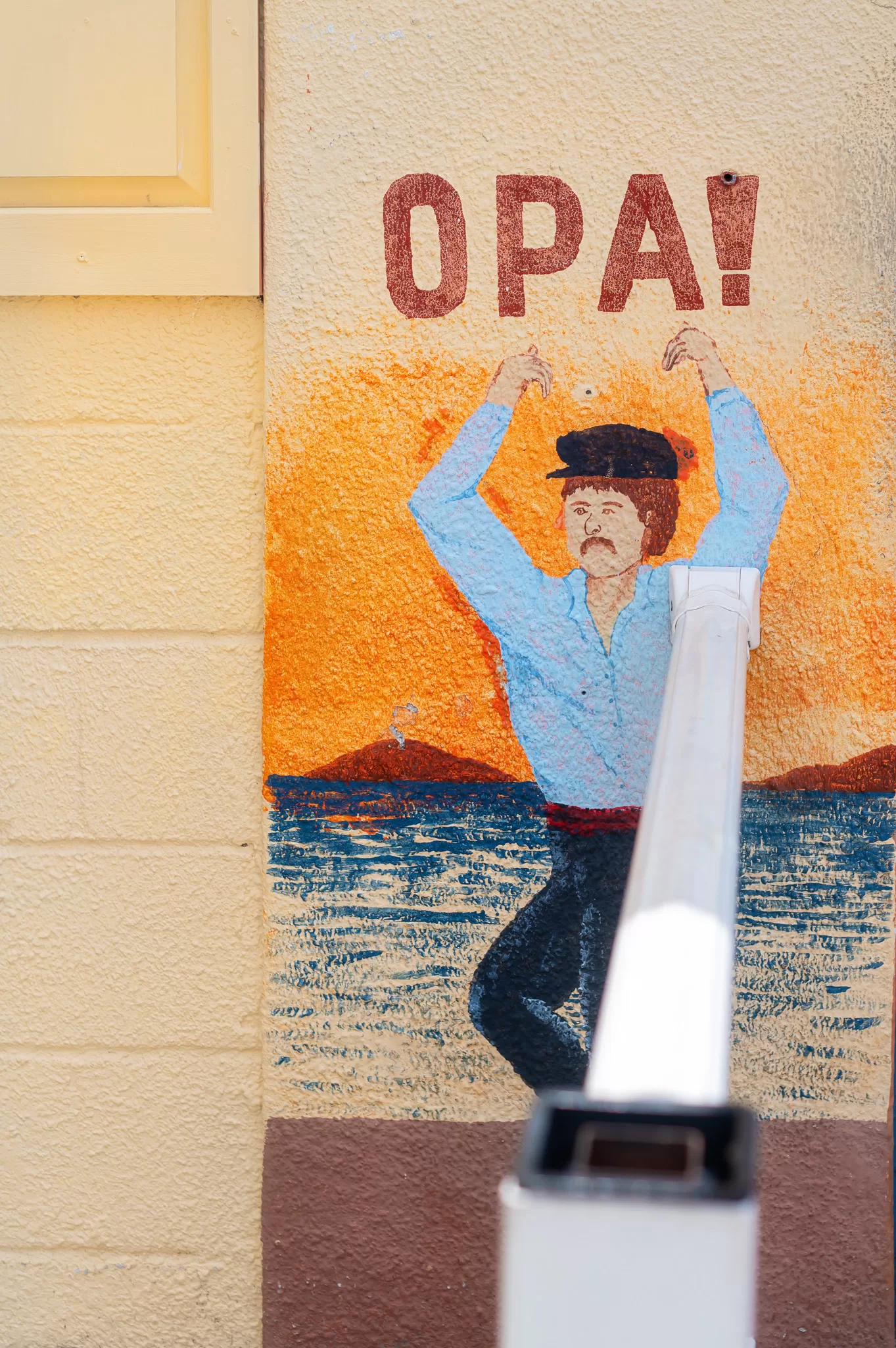 This image is for a blog post about Tarpon Springs Florida and shows a mural of a Greek man with the word OPA! above it.