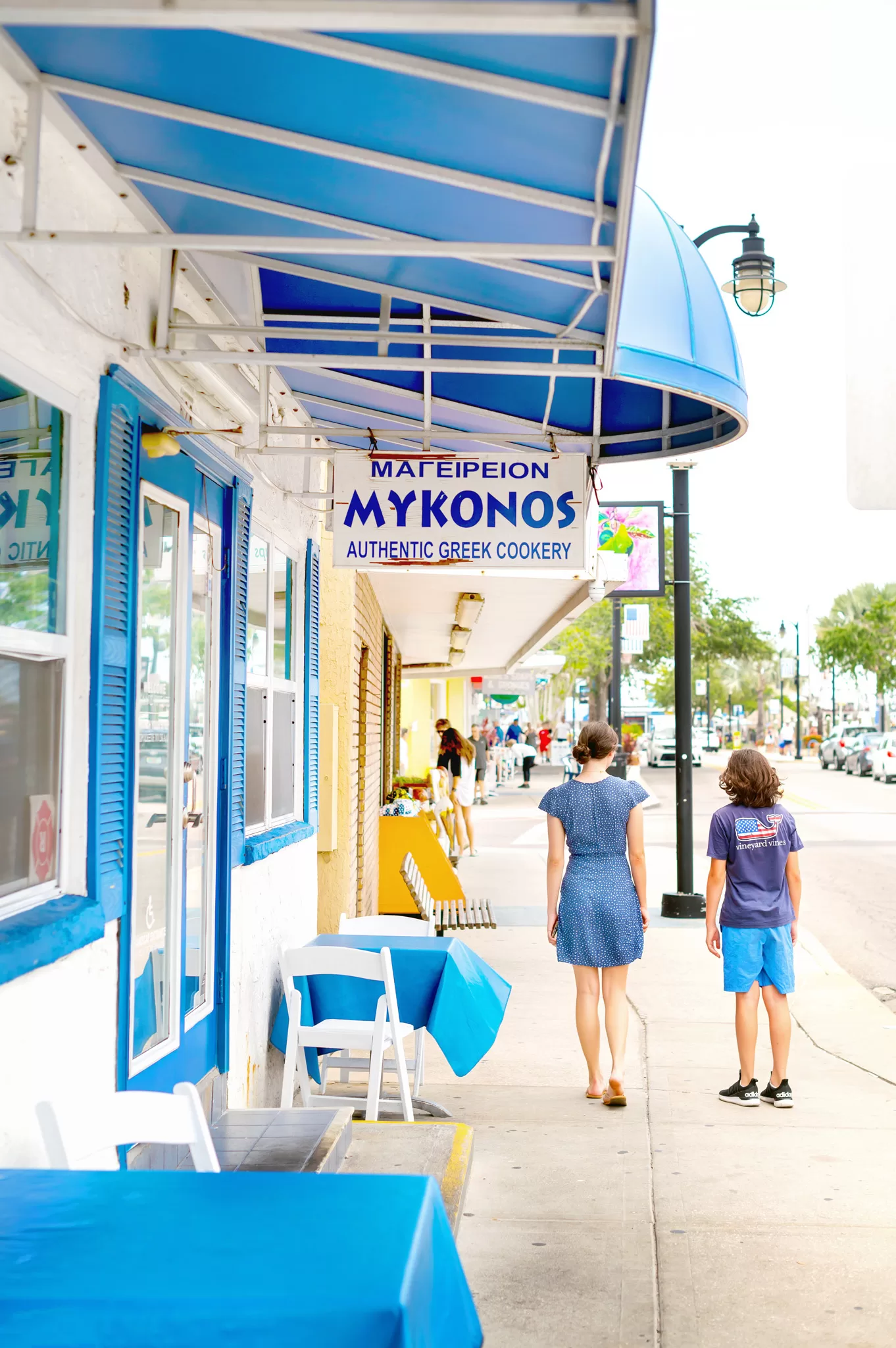 This image is for a blog post about Tarpon Springs Florida and shows two kids walking past the Mykonos restuarant in the greek part of town.