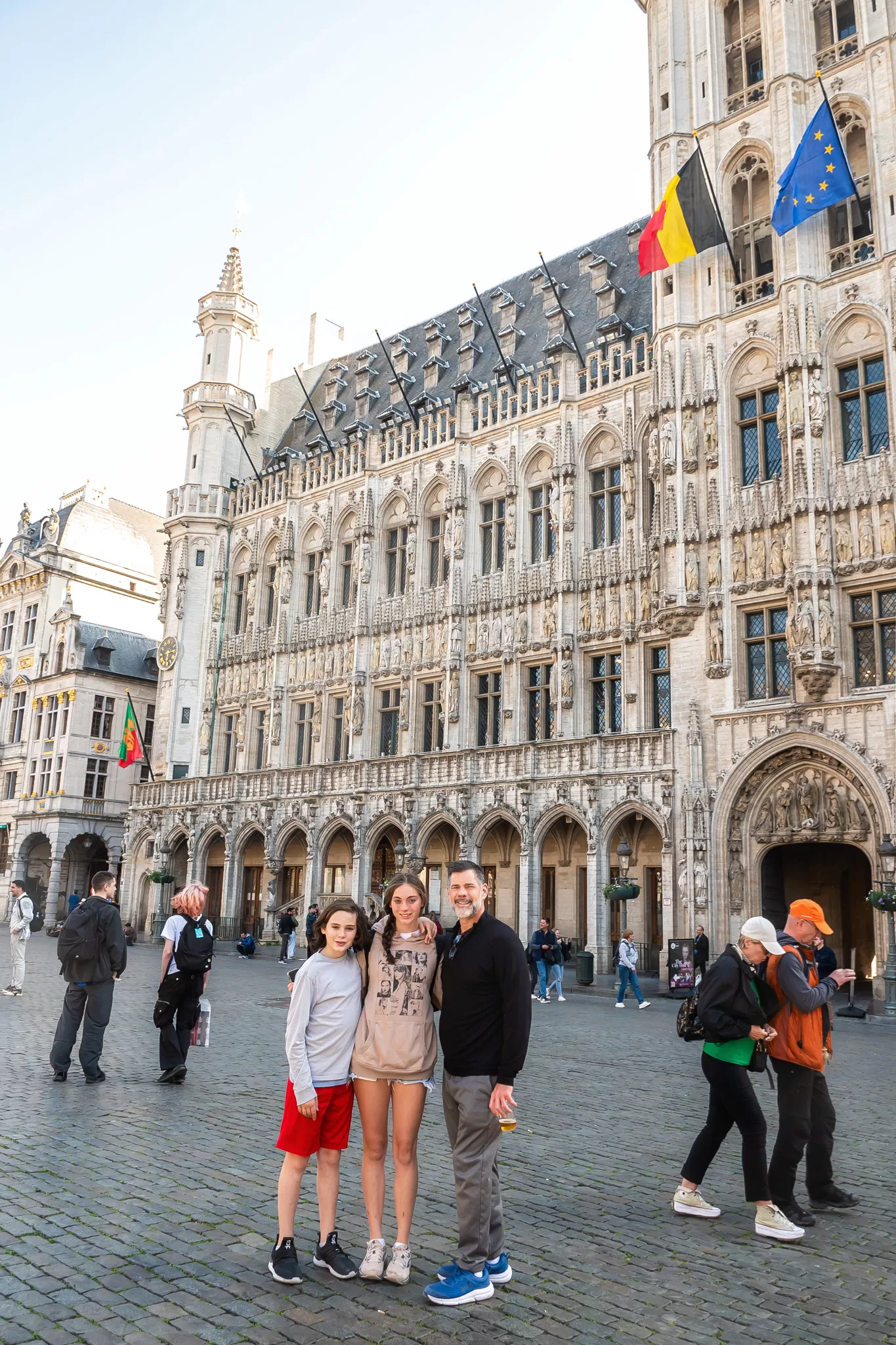 2 Days in Belgium Itinerary blog post. Image shows a day and two kids in Grand Place, Brussels.