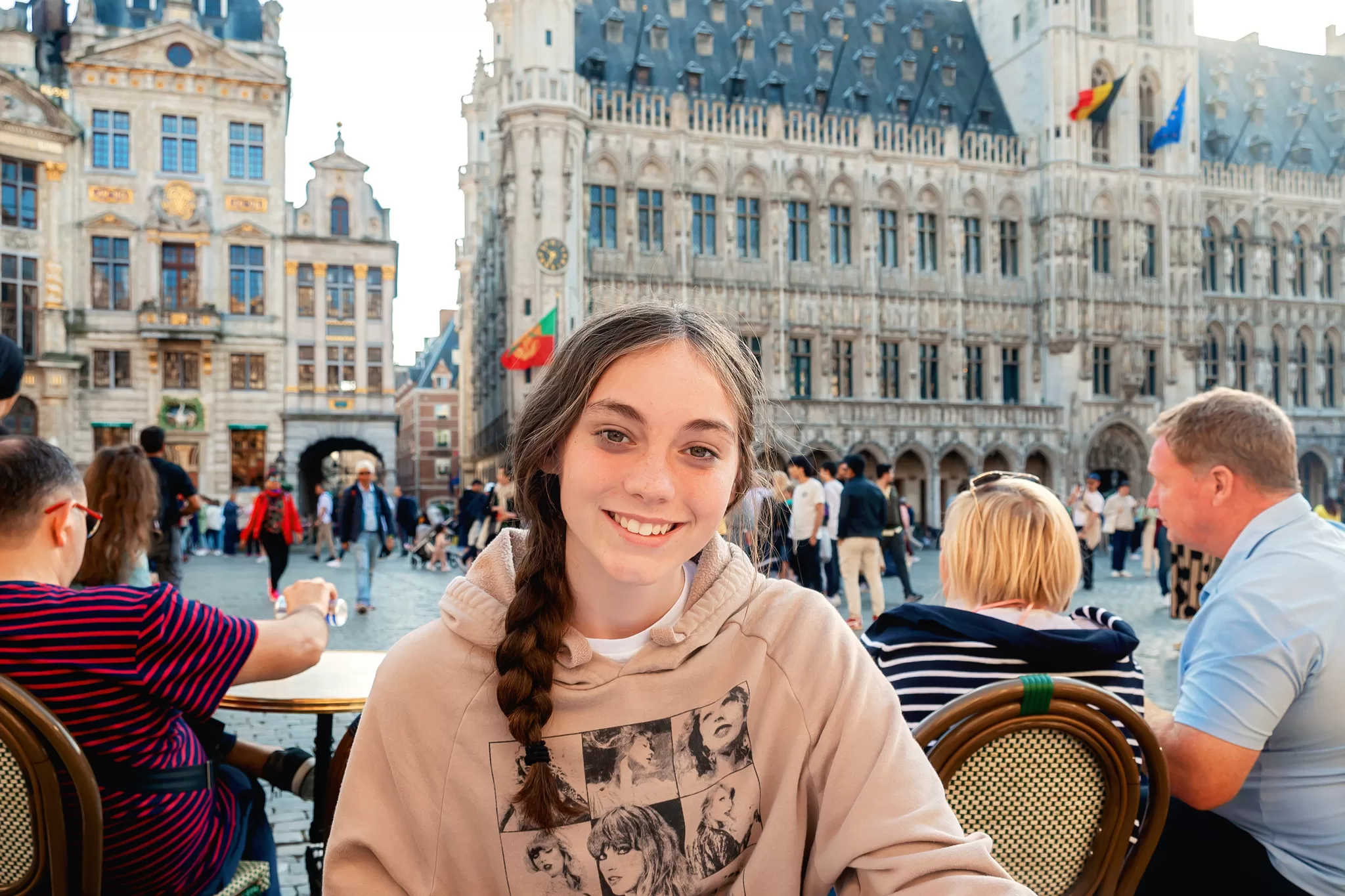 A teen girl sitting at an outdoor restaurant in Grand Place, Belgium Brussels 