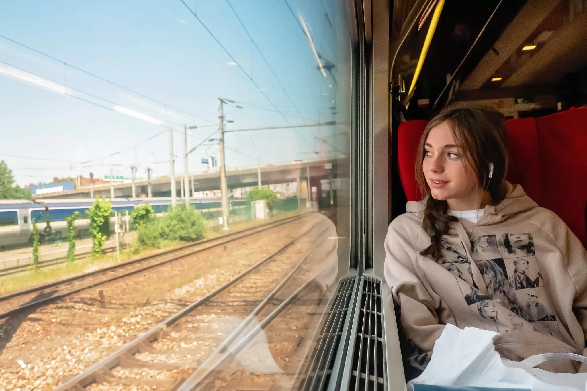 A teen girl on the Thalys train from Paris to Brussels.  She is looking out the window. 