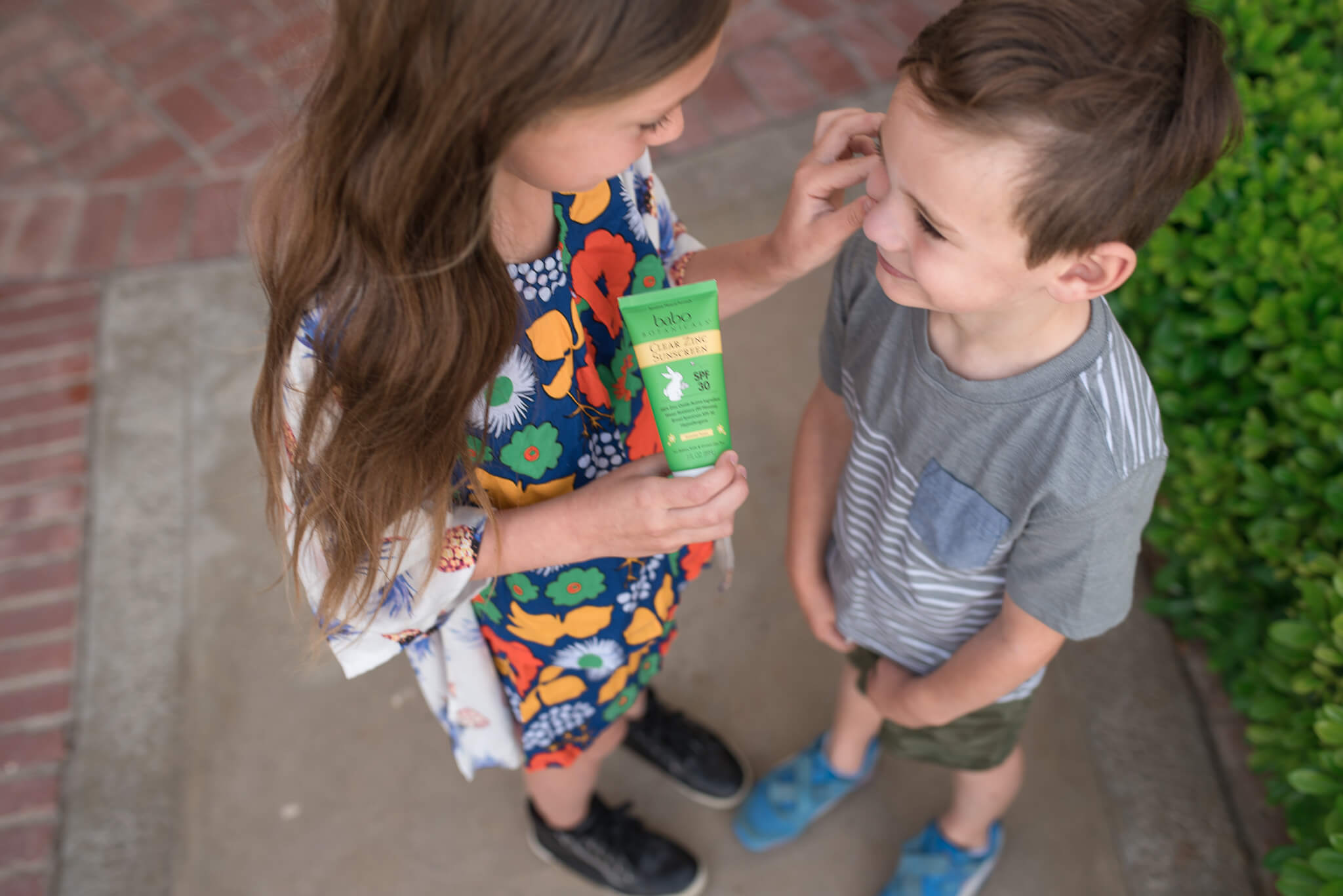 Kids applying Babo Botanicals Zinc sunscreen 