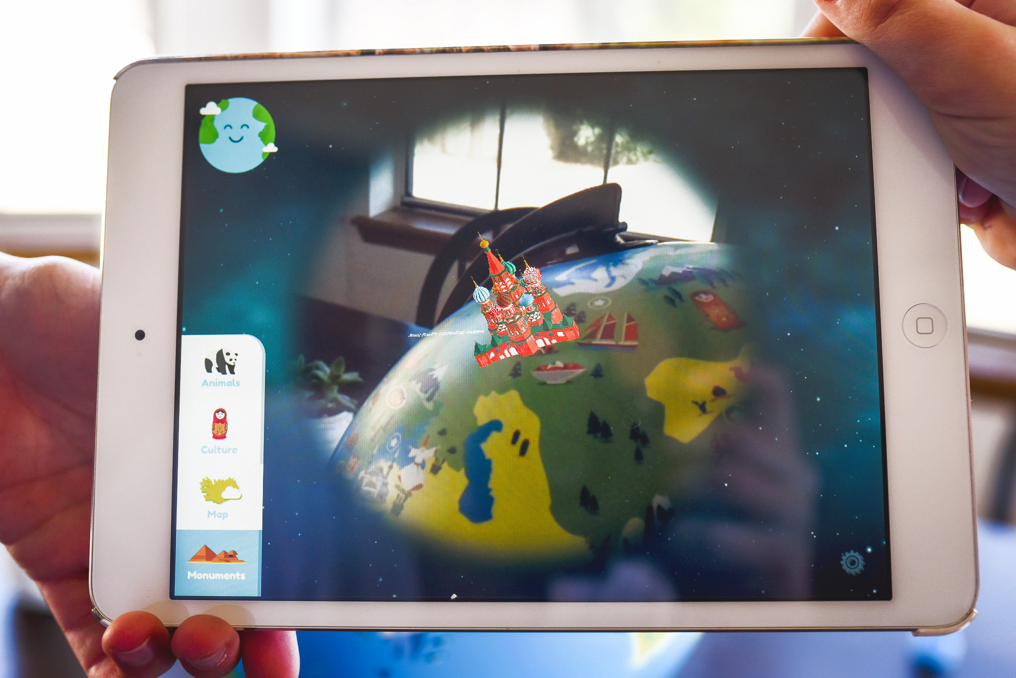 Orboot review - image shows two kids holding an ipad learning about the world on the Orboot Globe