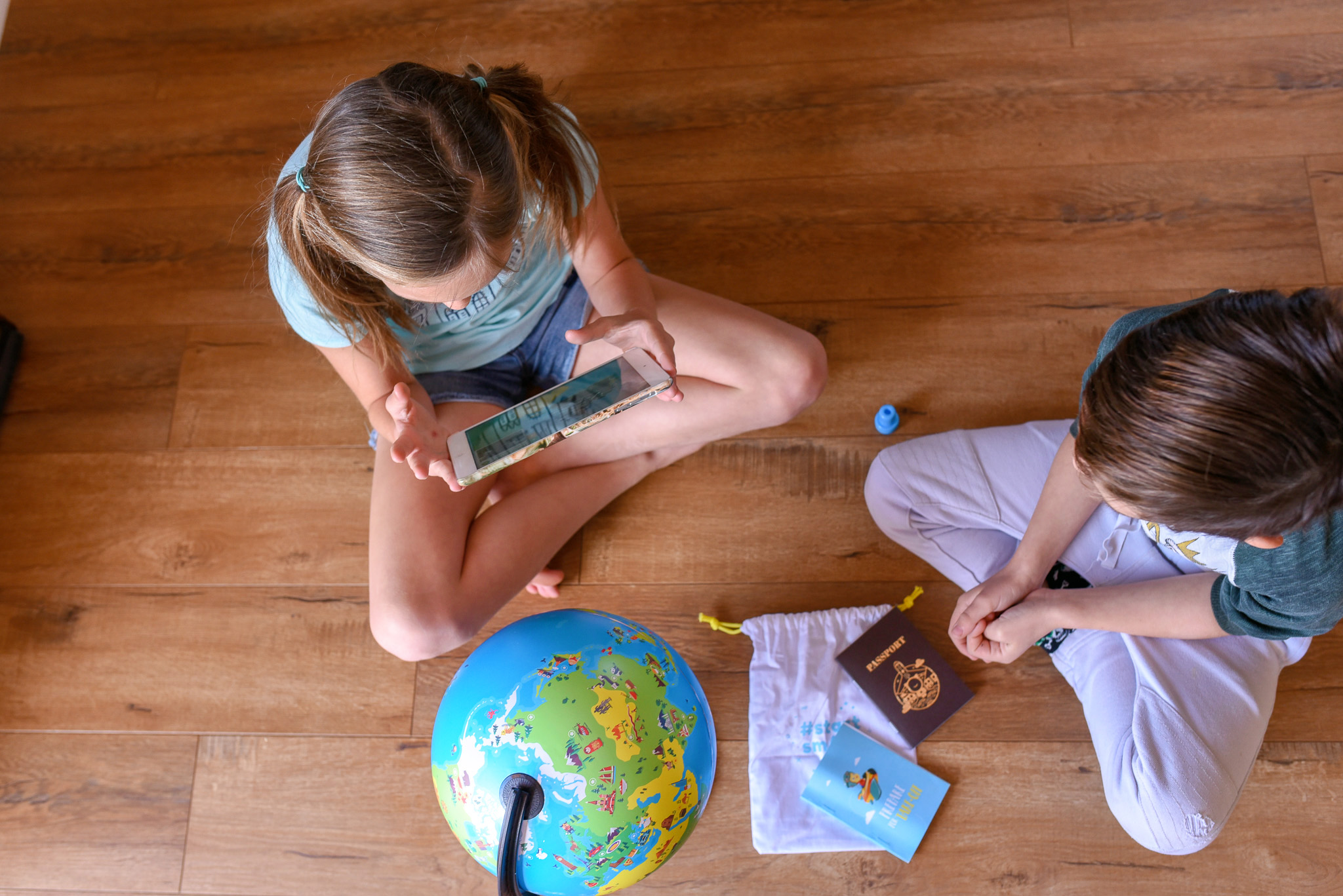 Orboot Globe  review - image shows two kids holding an ipad and learning about the world on the Orboot Globe