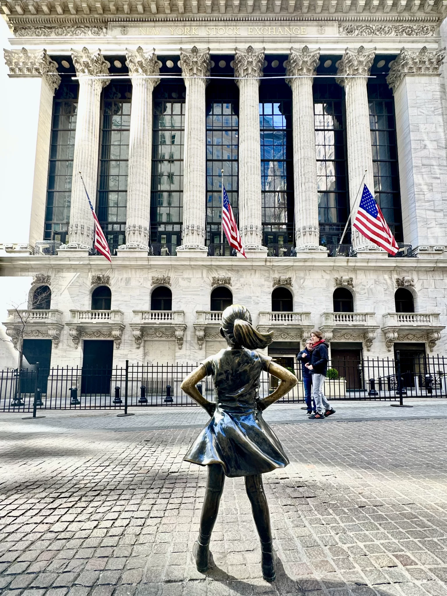 Fearless girl stading in from of the NYC stock exchange on Wall Street