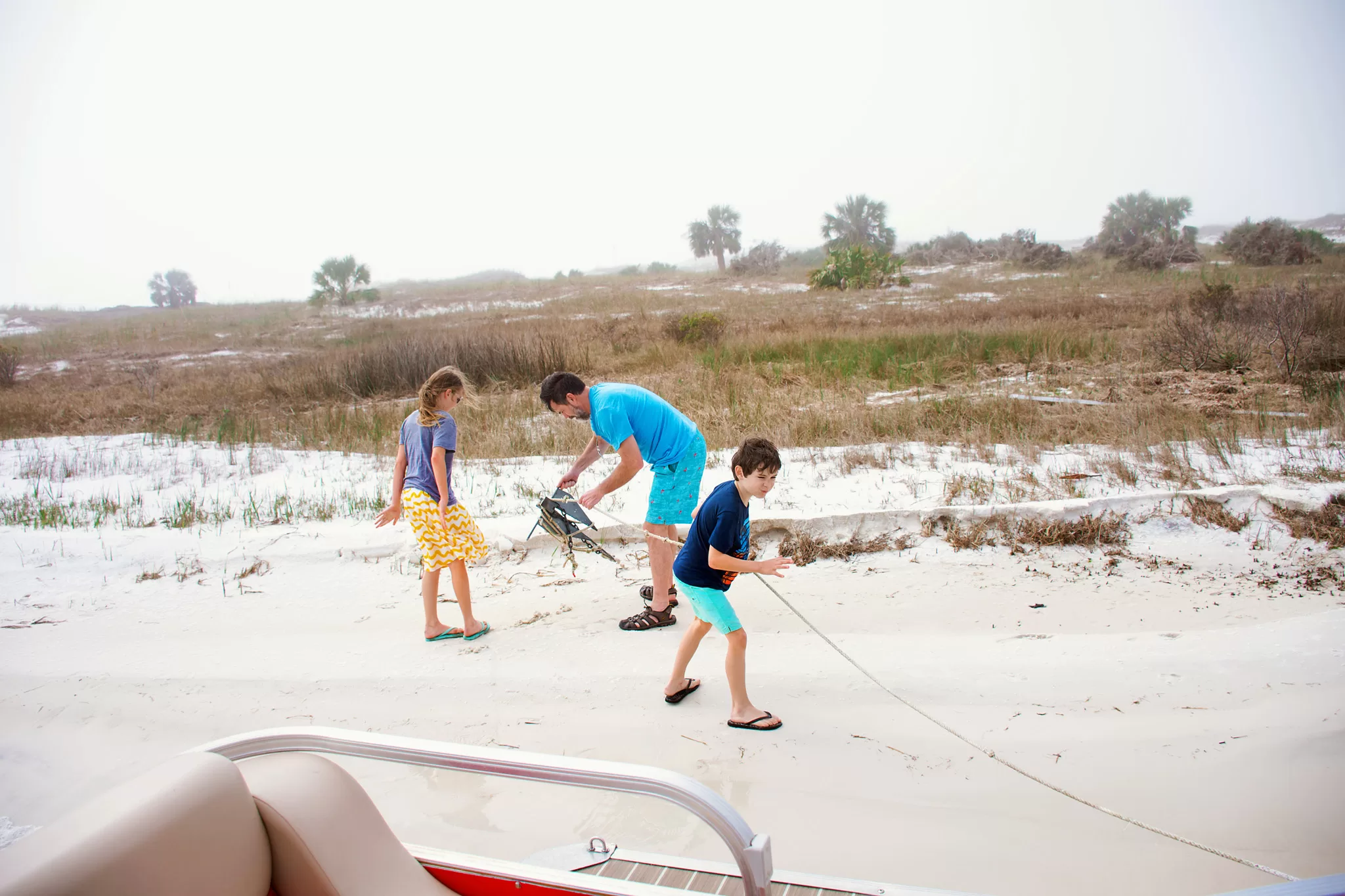 Kids anchoring a pontoon boat at at Shell Island in Panama City Beach