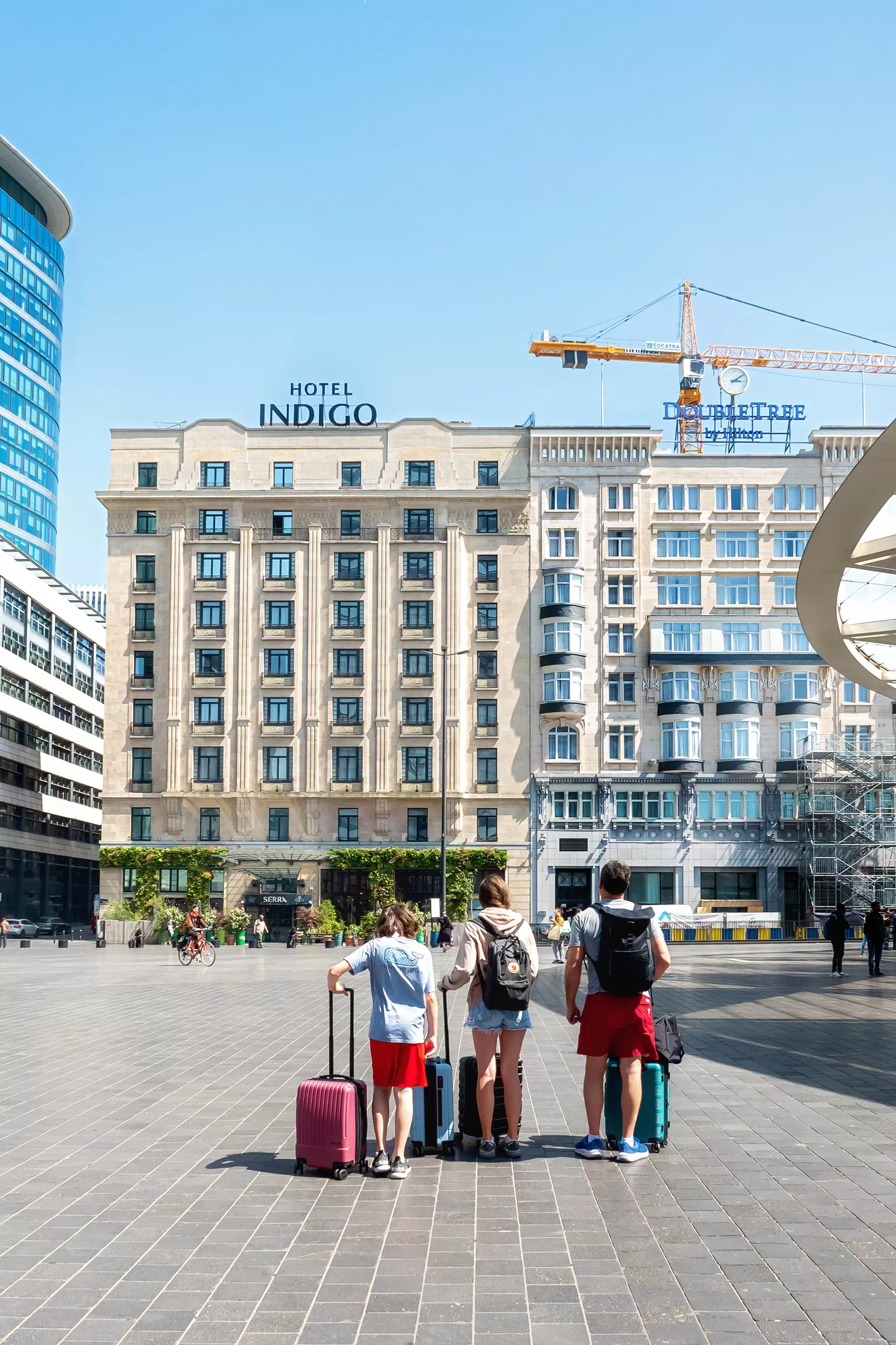 A family with suitcases in front of the Hotel Indigo Brussels City in Belgium Europe.