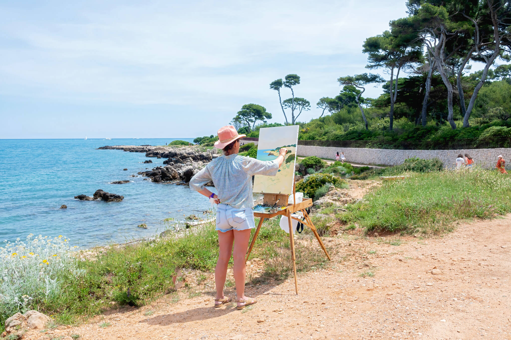 A painter painting on an easel along the hiking trail along the Cap d'Antibes Hike in Antibes France