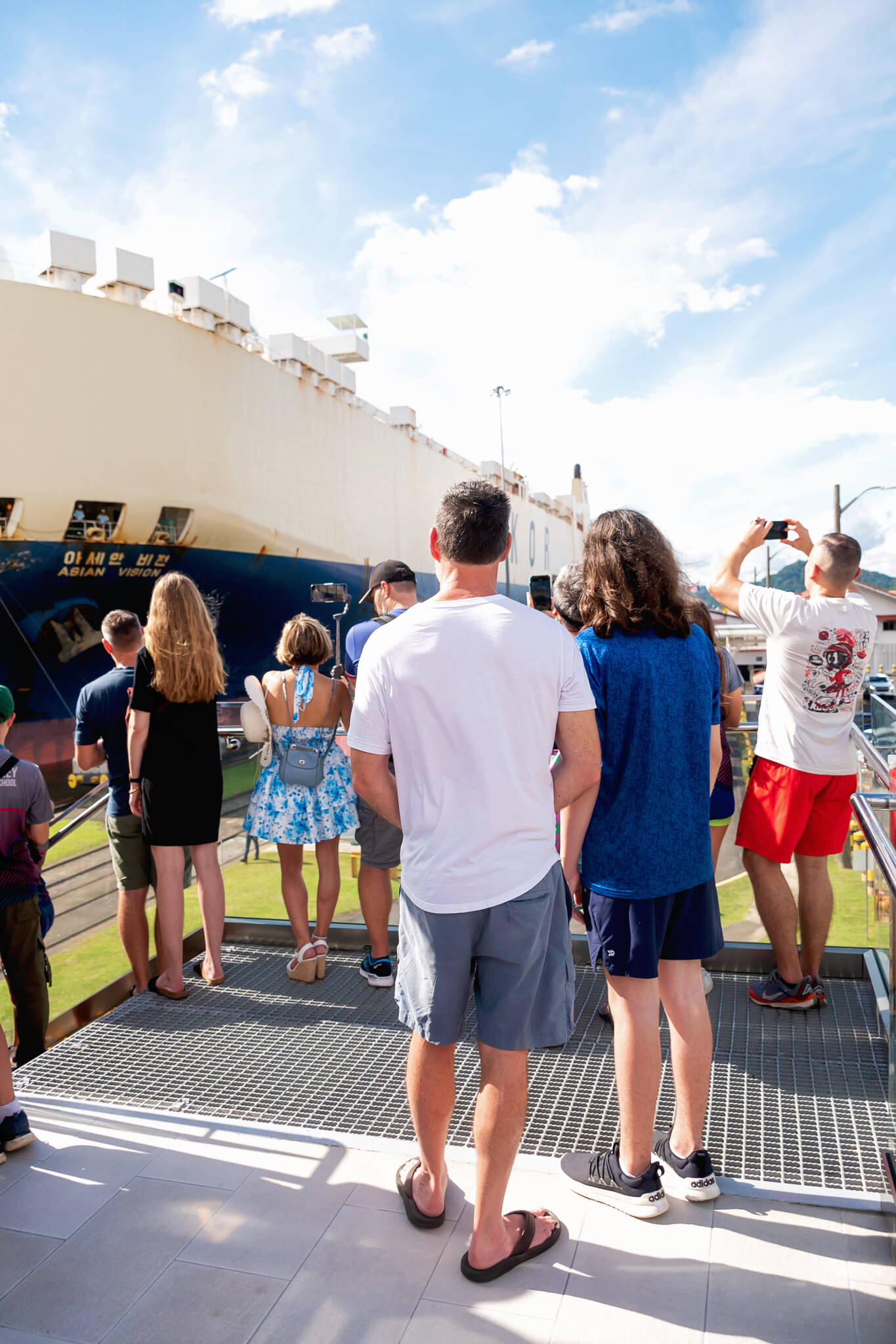 a father and son watching a ship cross the panama canal on a panama canal tour