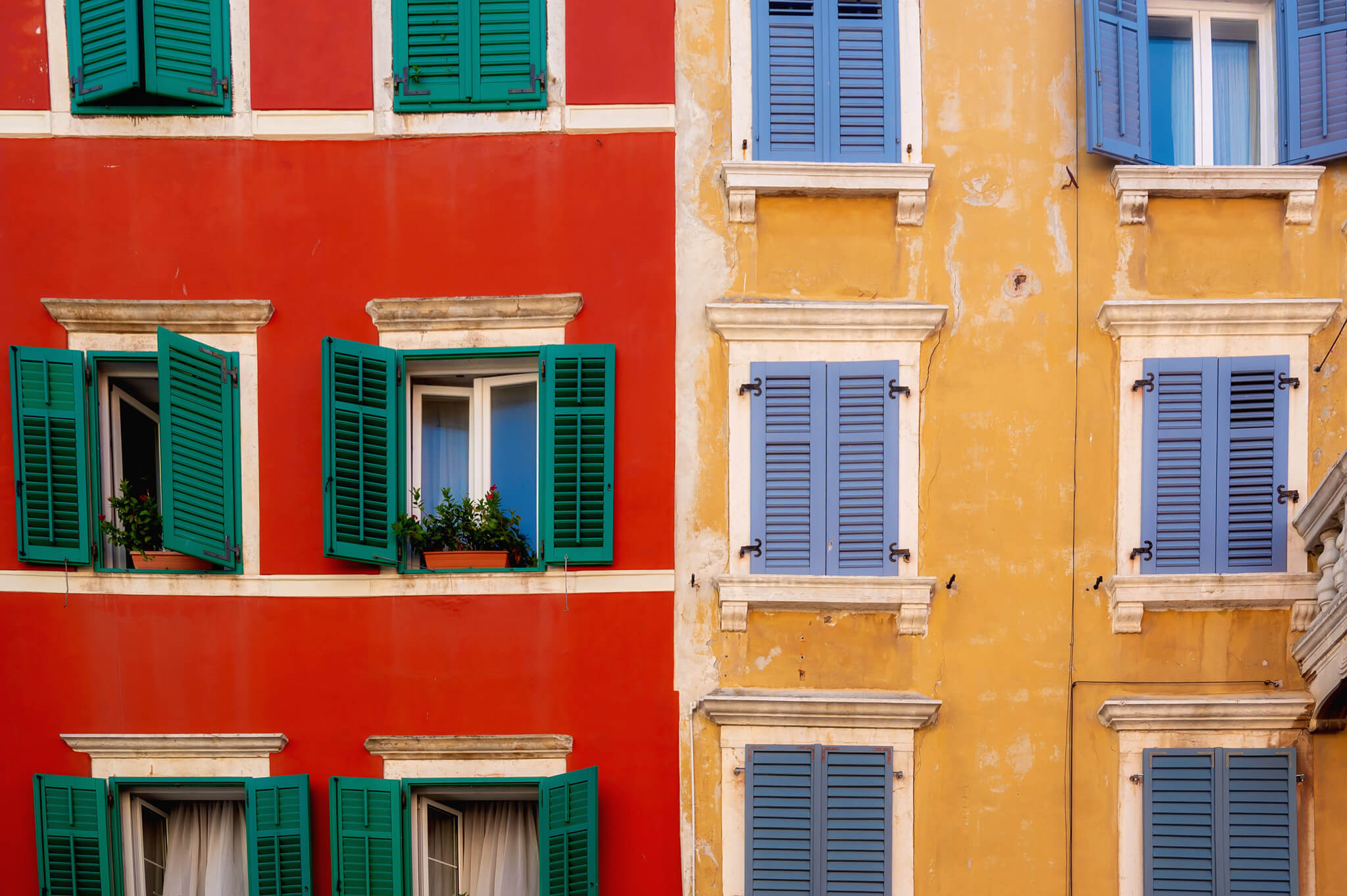 Colorful building facade with green and blue window shutters on a red and yellow wall. Star Clippers Royal Clipper Day 6 Rovinj Croatia