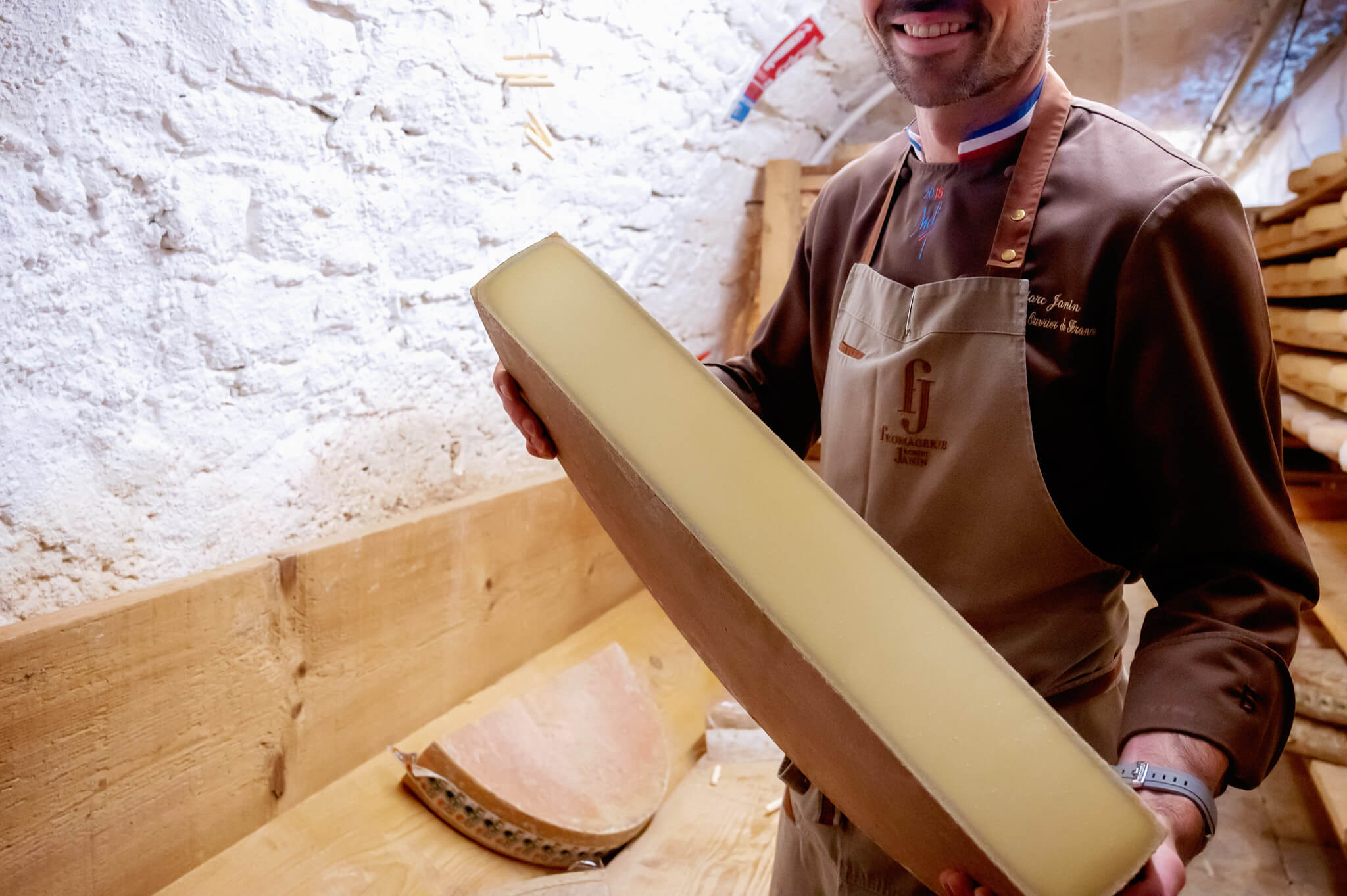 Marc Janin holding a comte cheese wheel he just opened